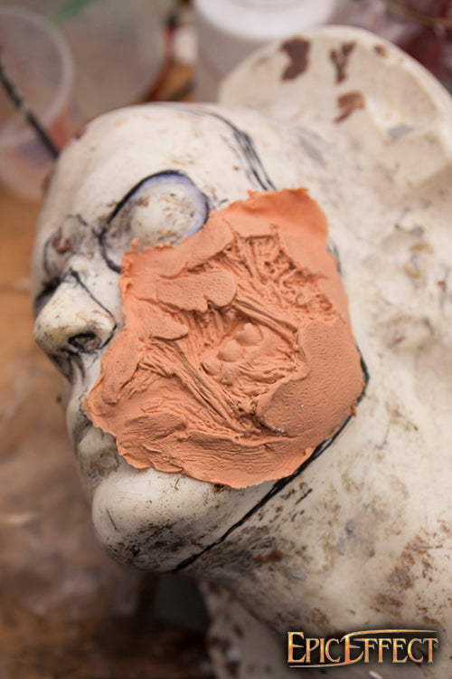 Zombie Cheek Torn prosthetic application on a sculpted head, showcasing realistic texture details.