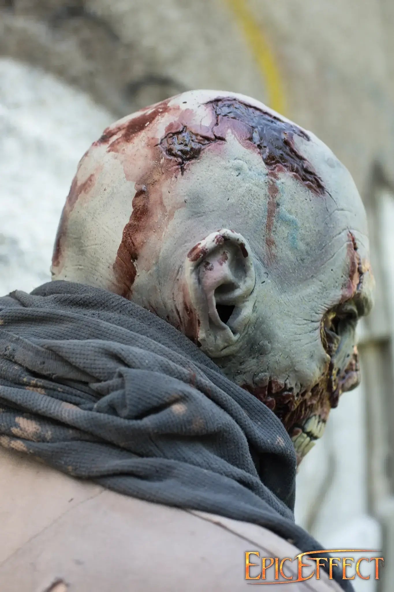 A detailed view of a Scarface Zombie with rotting skin and a grey scarf, evoking a sense of hunger and decay.