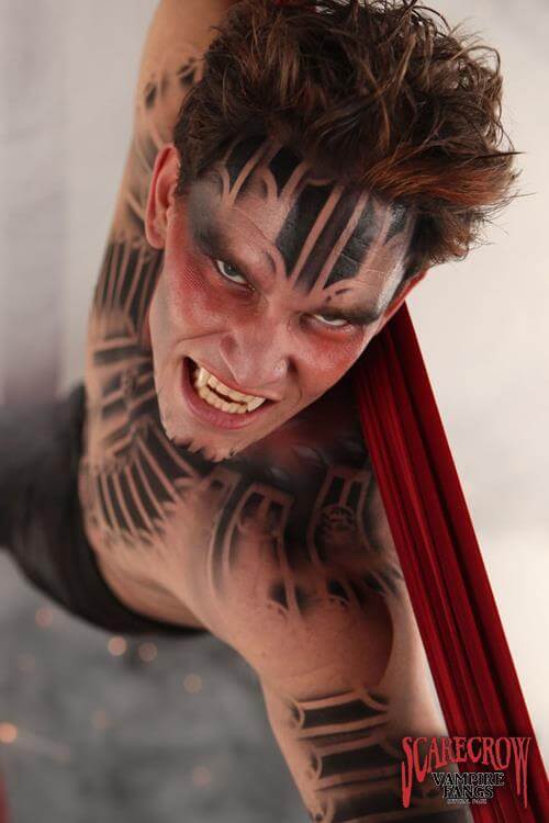 Model showcasing ScareCrow Vampire Fangs - Classic with striking makeup and dramatic pose.
