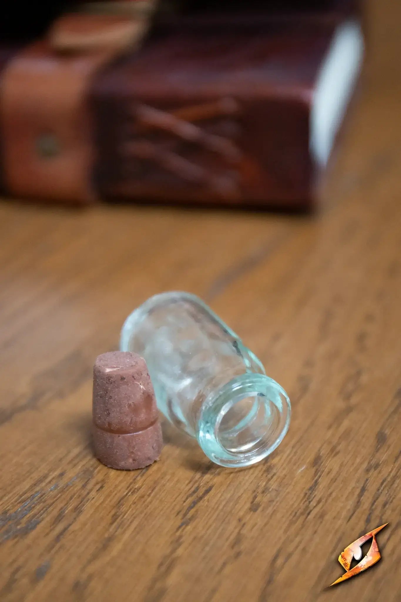 Potion Flask Small lying on a wooden table with a cork stopper nearby.