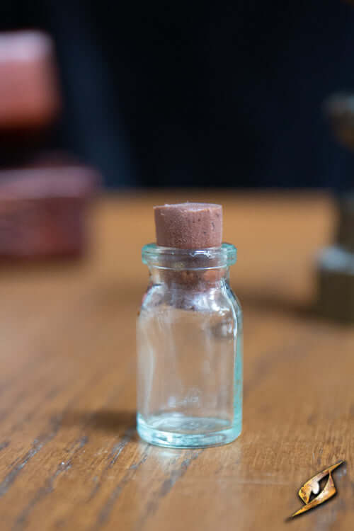 Potion Flask Small displayed on wooden table, featuring a cork stopper and transparent glass design.
