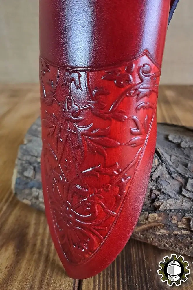 Dagger Holder Jerome (Fighter) with intricate red leather detailing on a wooden background.