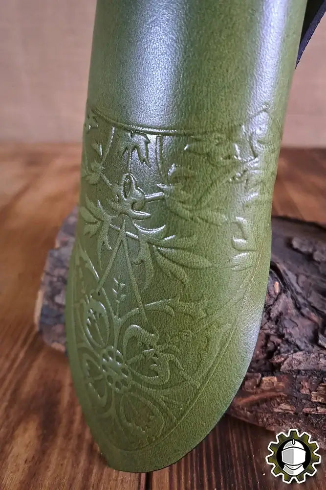 Dagger Holder Jerome (Fighter) made of green leather with intricate detailing on wood background.