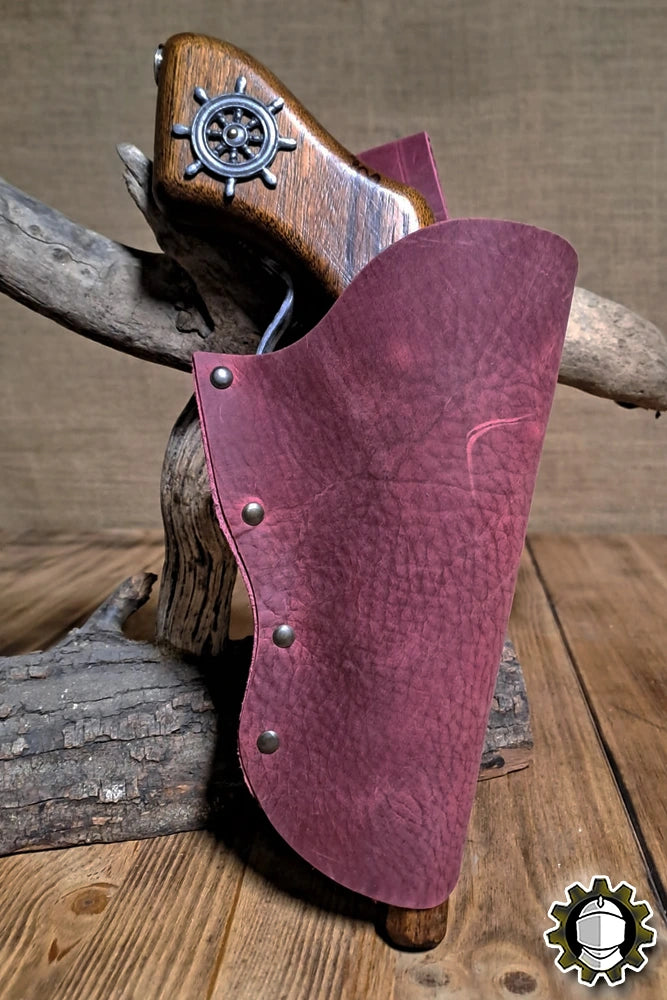 Holster Patrick (New Blood) in maroon leather, securely holding a vintage-style weapon on a wooden display.