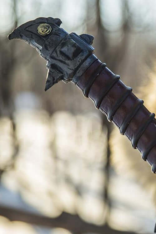 Close-up of the Baen Si II sword handle showcasing its unique design and deep red wrappings.