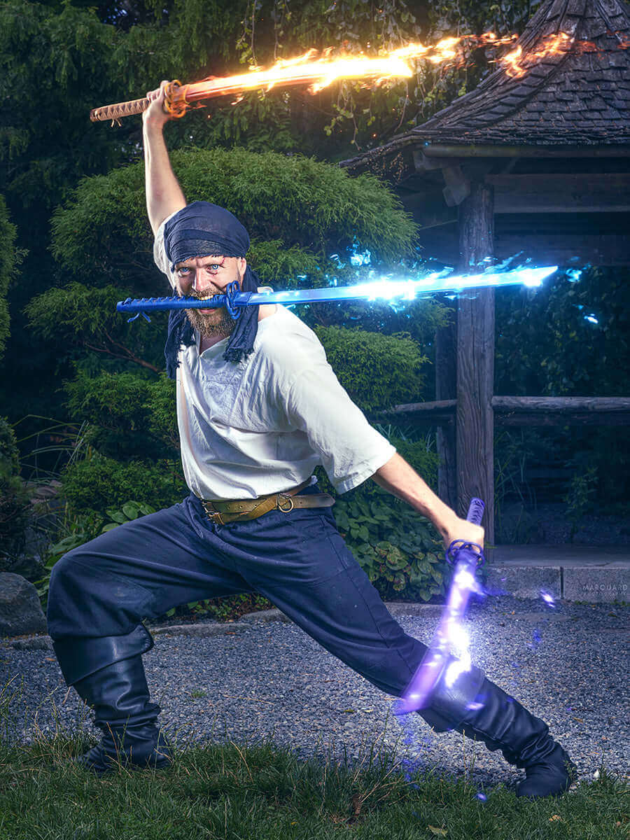 Warrior posing dramatically with flaming and glowing swords in a garden setting.