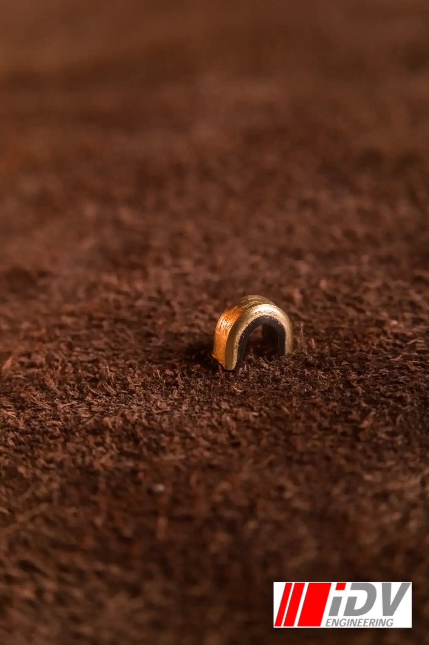 Close-up of a String Nock Marker on a brown surface, showcasing its detail and design.