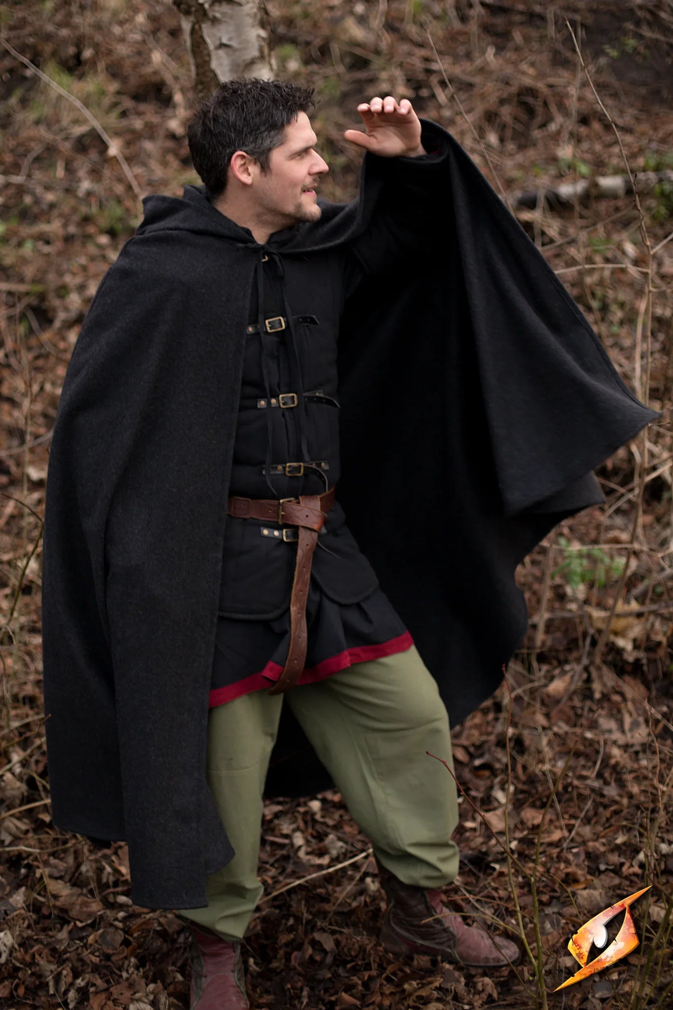 Man wearing a Cape Wool cape outdoors, showcasing the cloak's deep hood and heavy wool blend fabric.