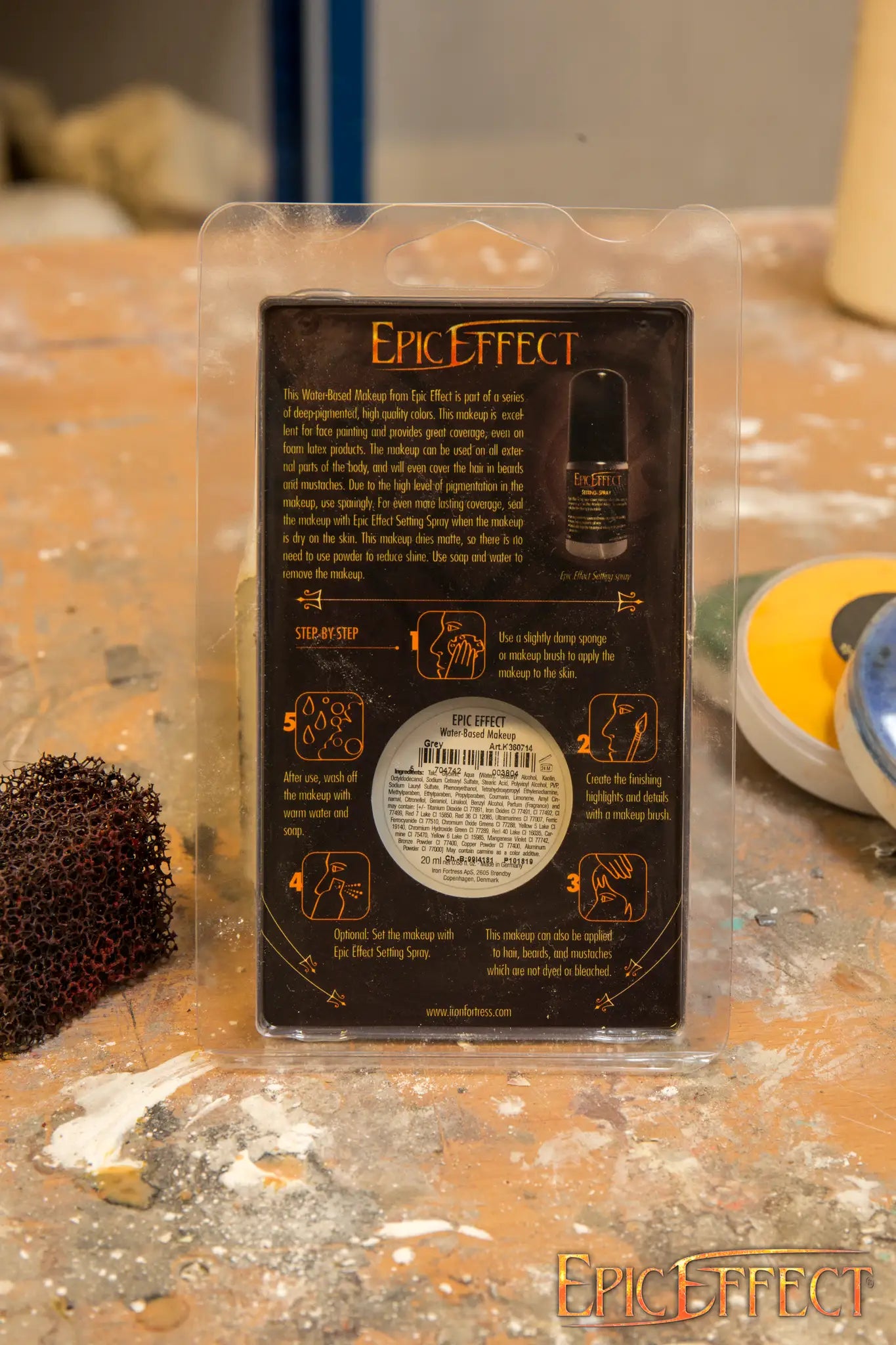 Water Based Make Up - Light skin product packaging with application instructions and details on a workbench.