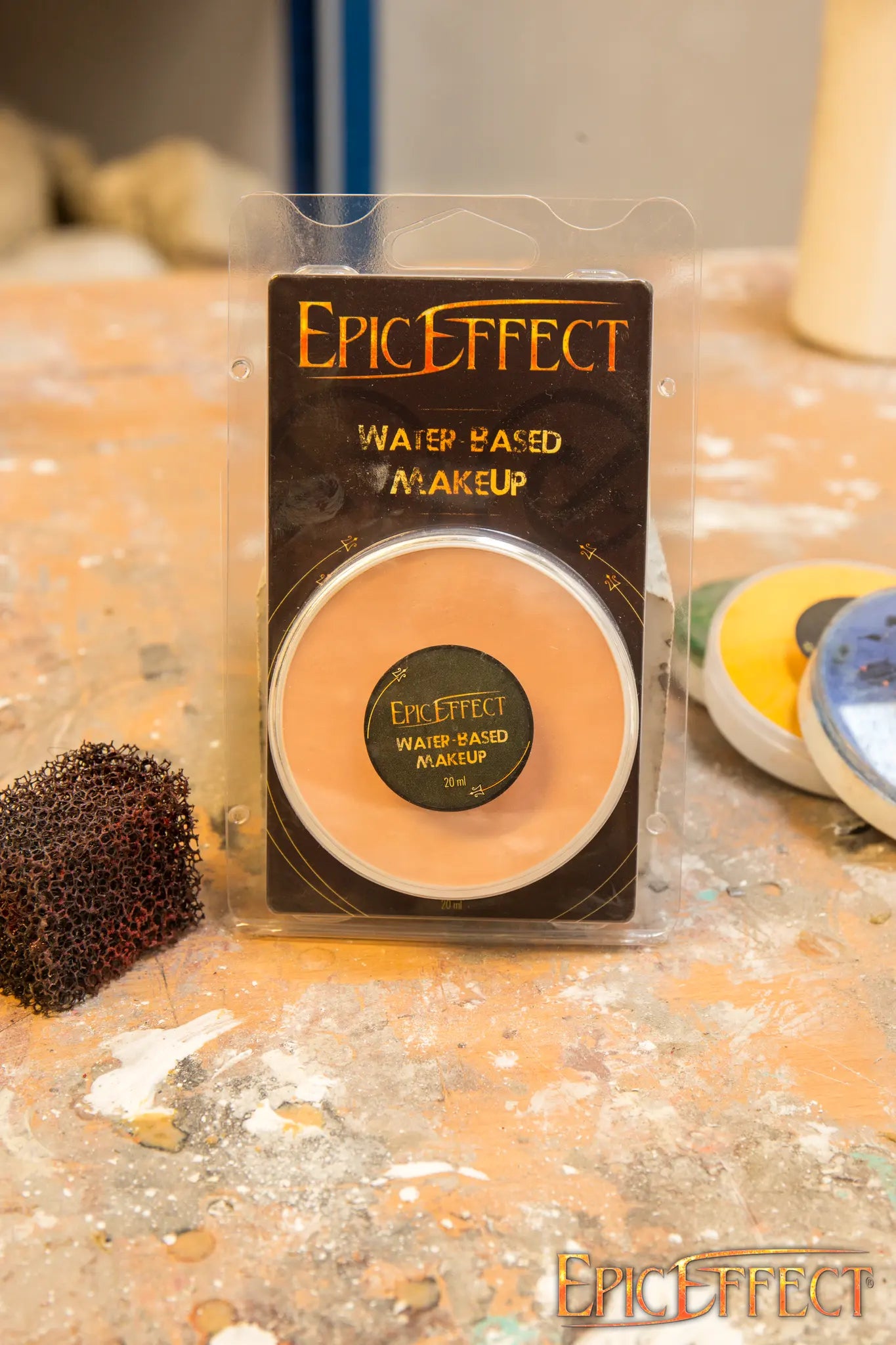 Epic Effects Water Based Make Up - Light skin in compact form on a workshop table with tools.
