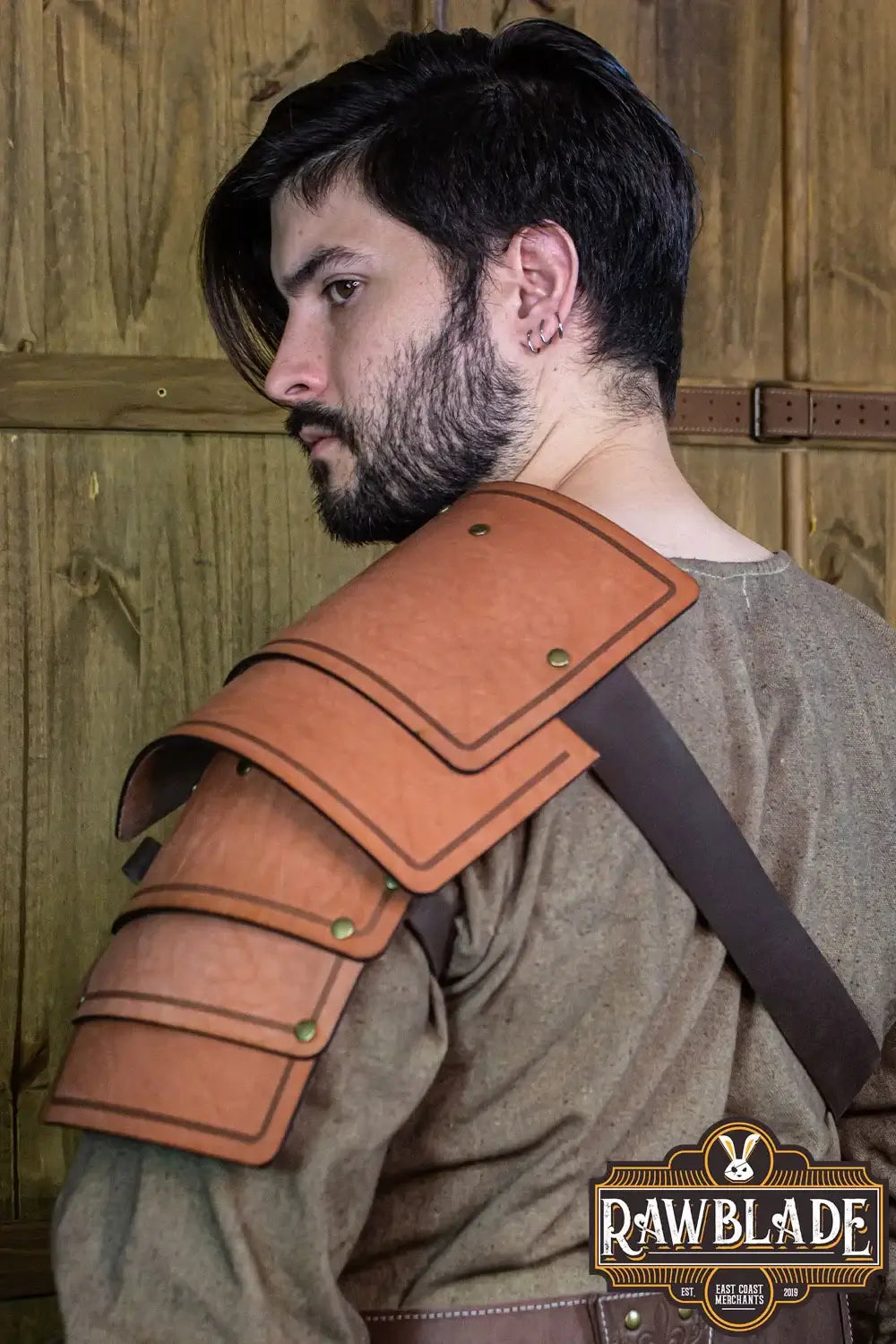 Adventurer Shoulder worn by a man, showcasing aged leather for a realistic look in a rustic setting.