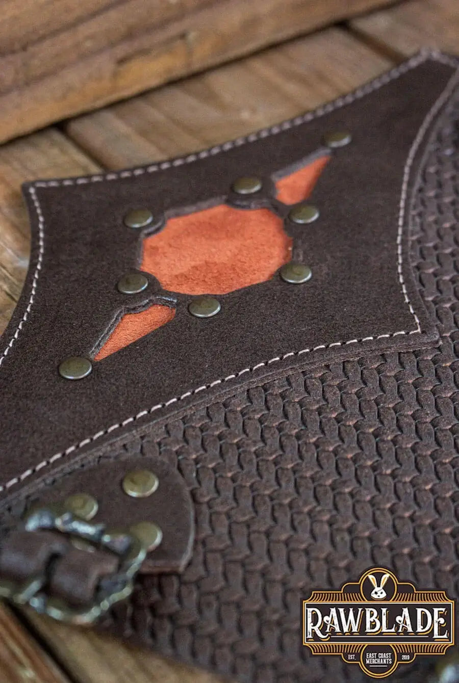 Close-up of a Beljant Bracer featuring decorative studs and a vibrant orange diamond inlay.
