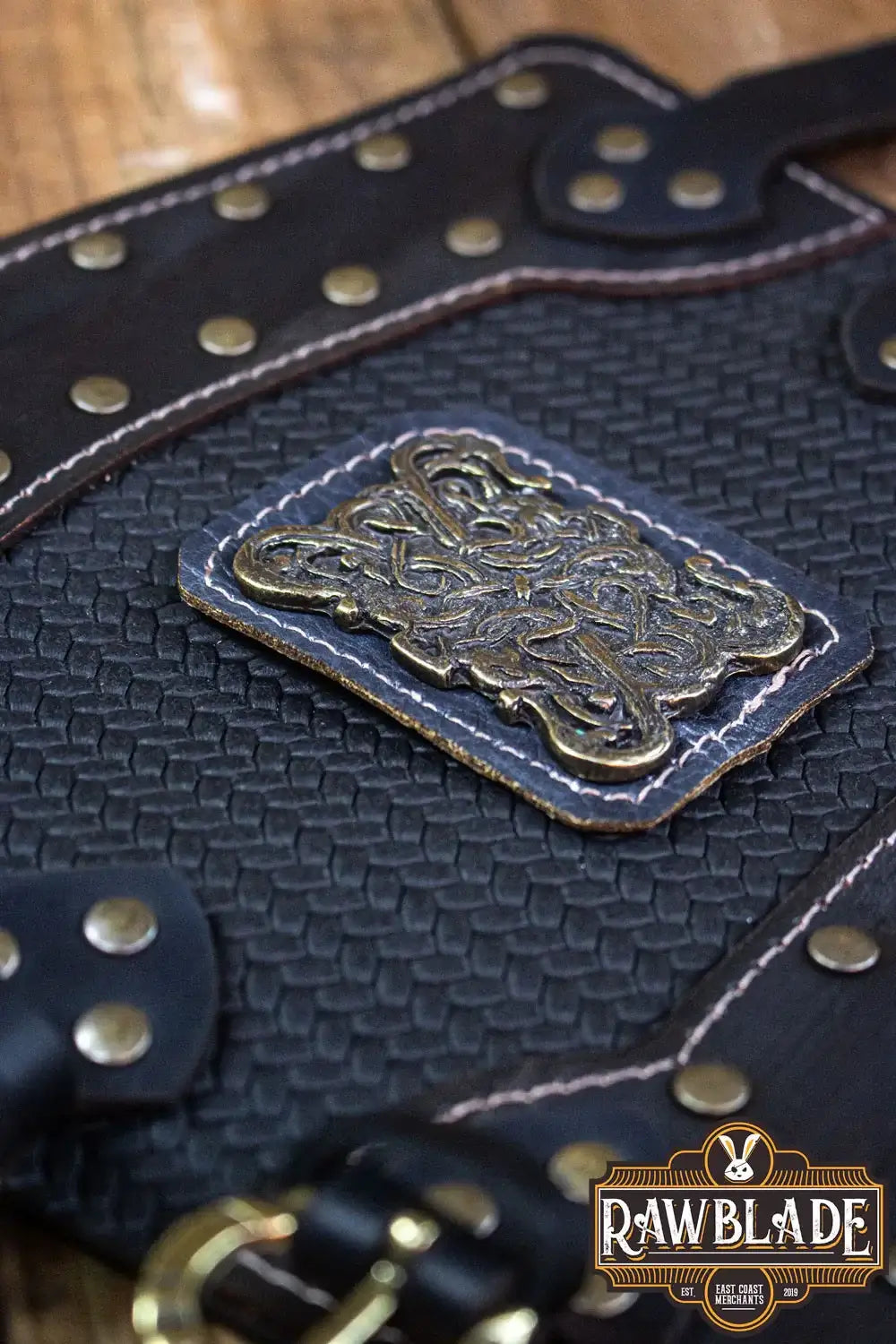 Close-up of Bruce Bracers showcasing detailed leather texture, rivets, and an ornate metal emblem.