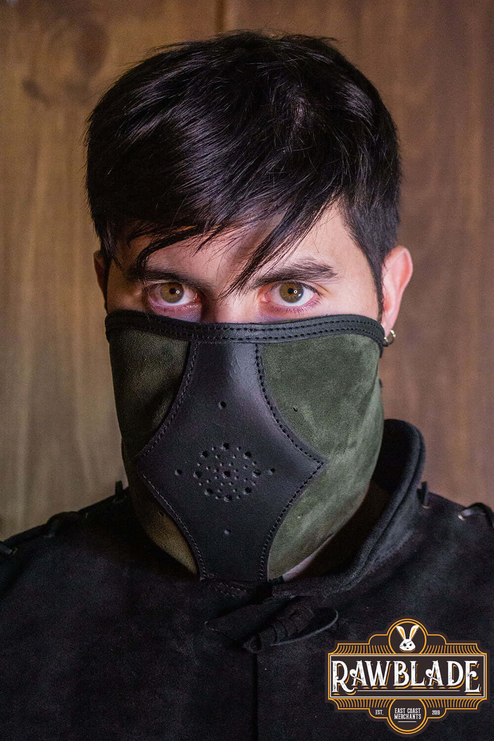 Akku Splitleather Hood featuring a stylish mask worn by a model with dark hair and piercing eyes.