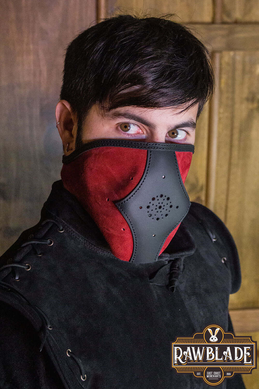 Akku Splitleather Hood worn by a person against a rustic background, showcasing its unique leather and metal design.