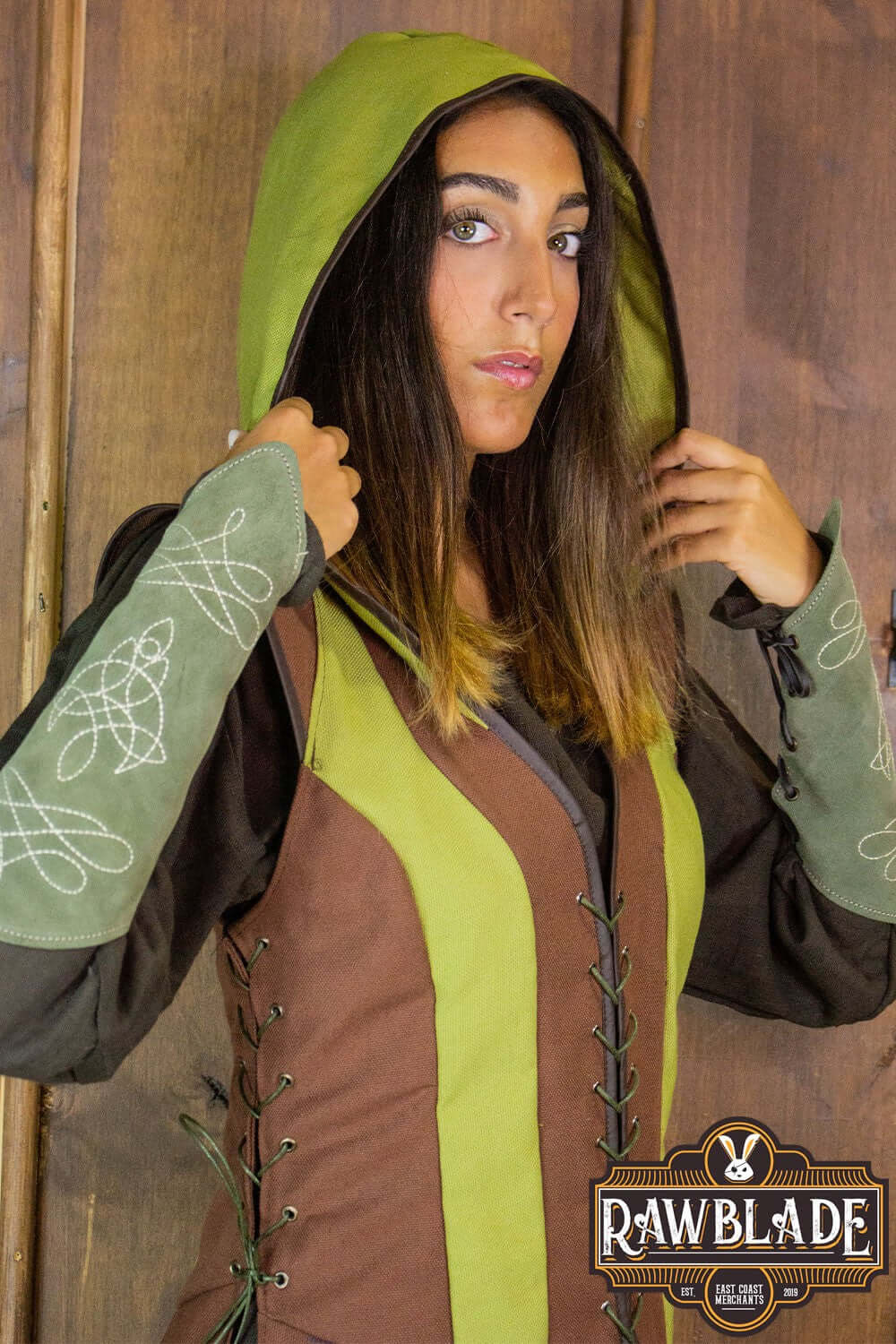 Arylith Archer Cotton Tunic worn by a woman, featuring a green hood and brown detail, adjustable drawstrings.