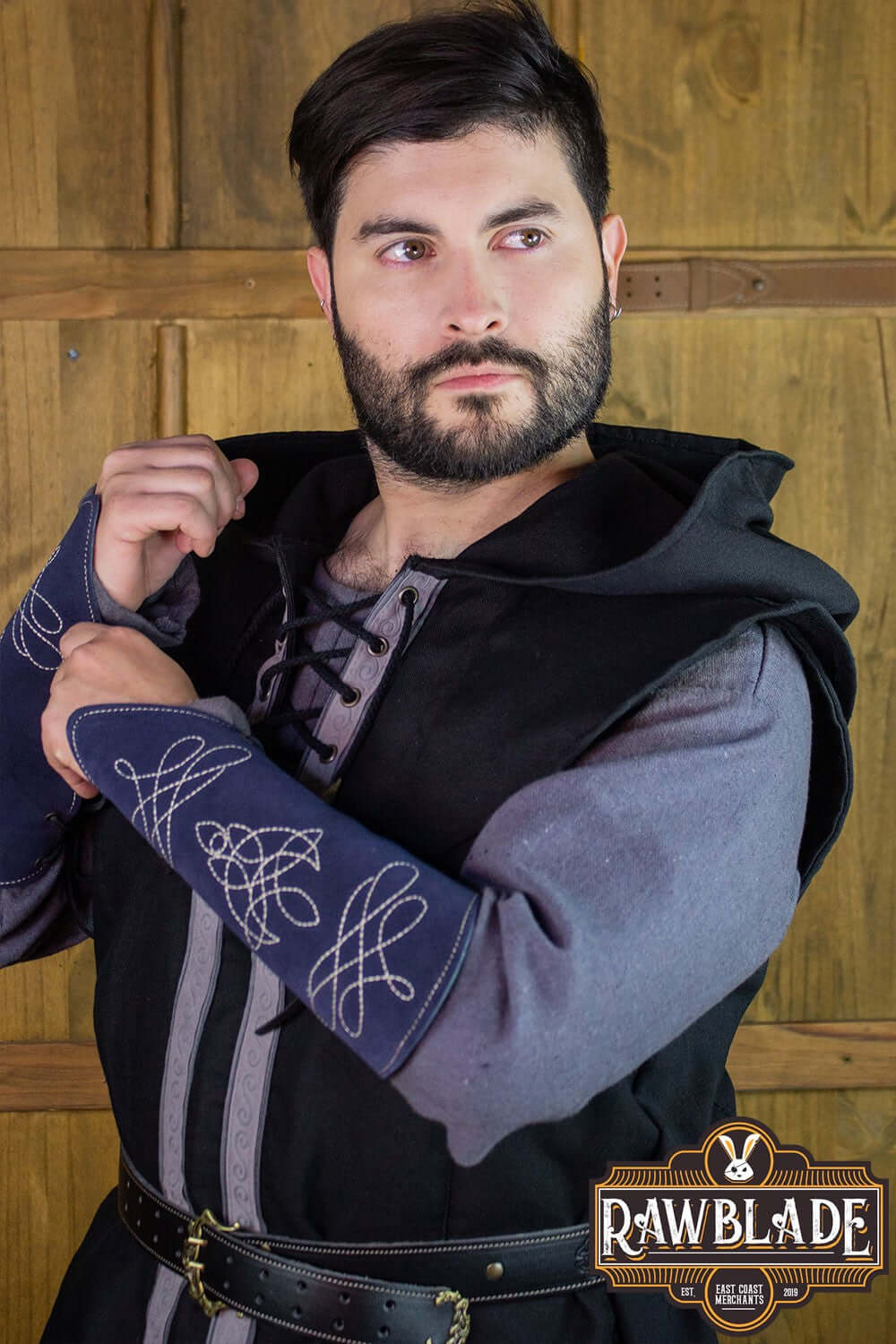 A model wearing the Karanthir Tunic with a wide hood, perfect for young wizards or elven trackers.