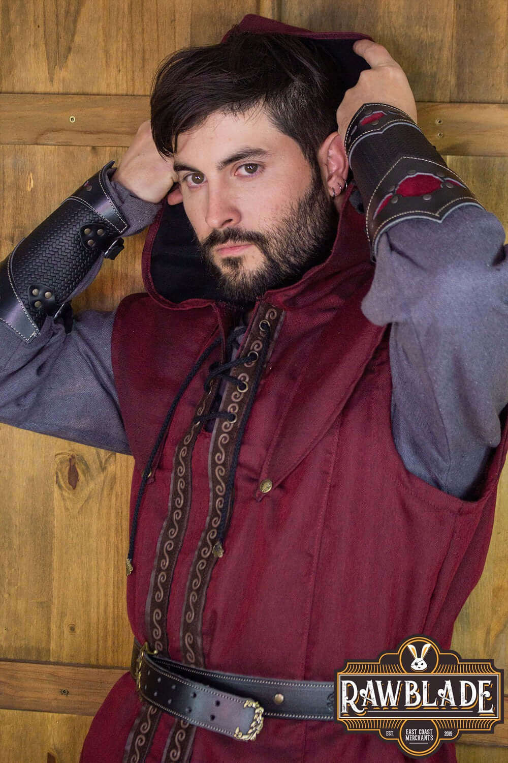 Man adjusting the hood of the Karanthir Tunic from Rawblade, showcasing its stylish design and versatility.