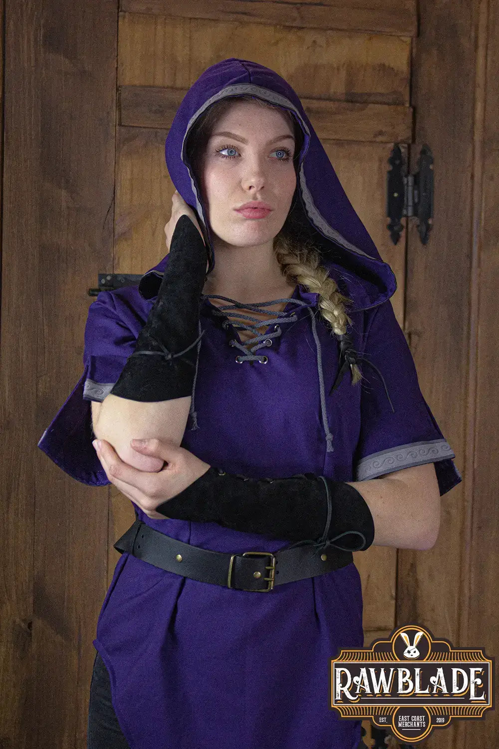 A model wearing the Briannan Ranger Tunic in purple with a wide hood and black suede trims.