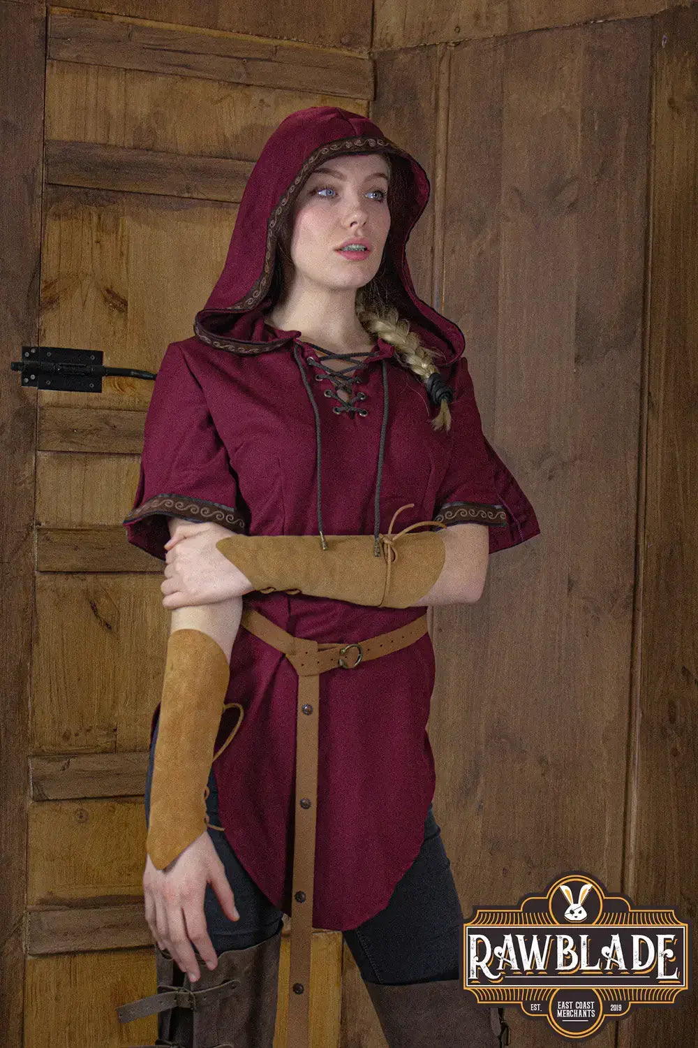 Briannan Ranger Tunic featuring a wide hood, short sleeves with leather trims, worn by a model in a rustic setting.