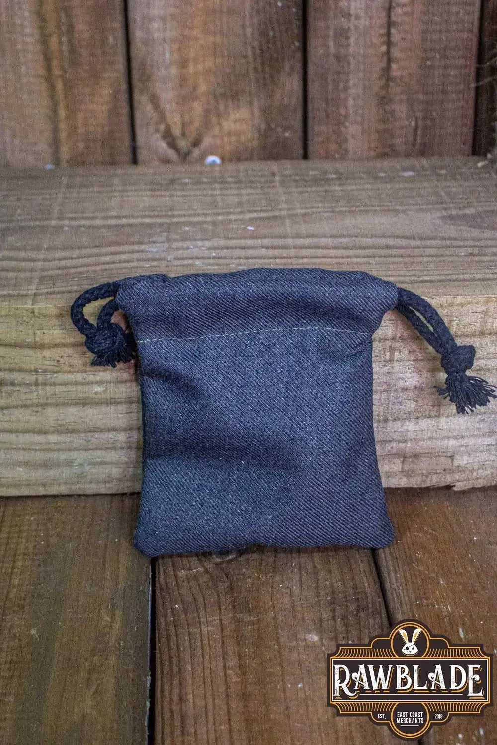 Timber Pouch Premium in black cotton on wooden surface, showcasing high-quality craftsmanship from Spain.