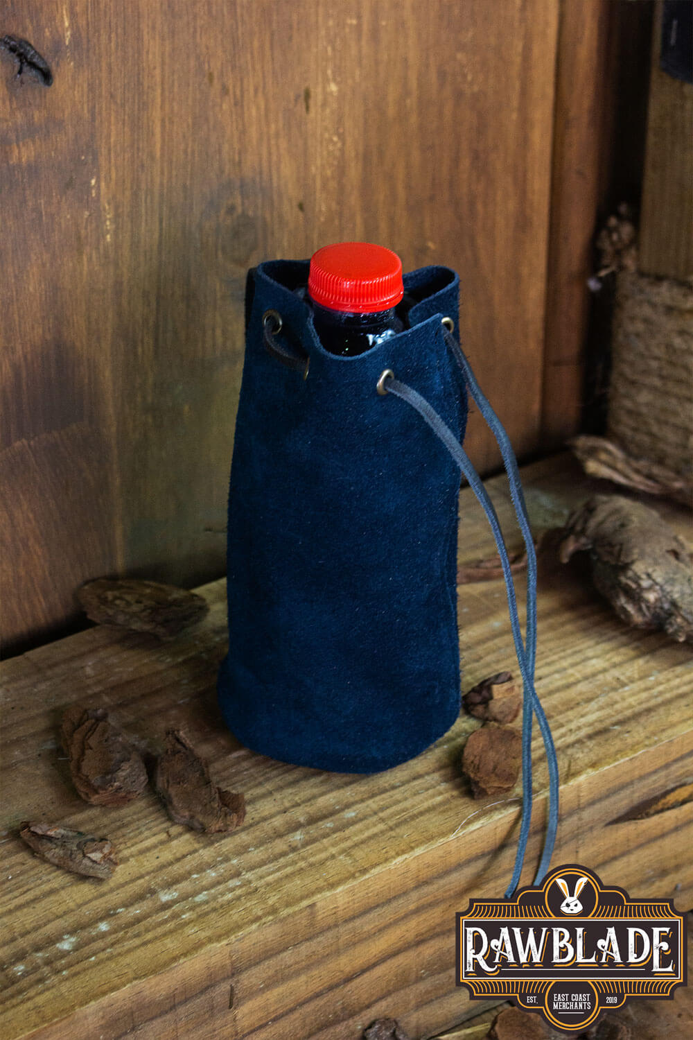 Adventurer Tube Pouch displaying a blue suede bag holding a water bottle, ideal for carrying essentials.