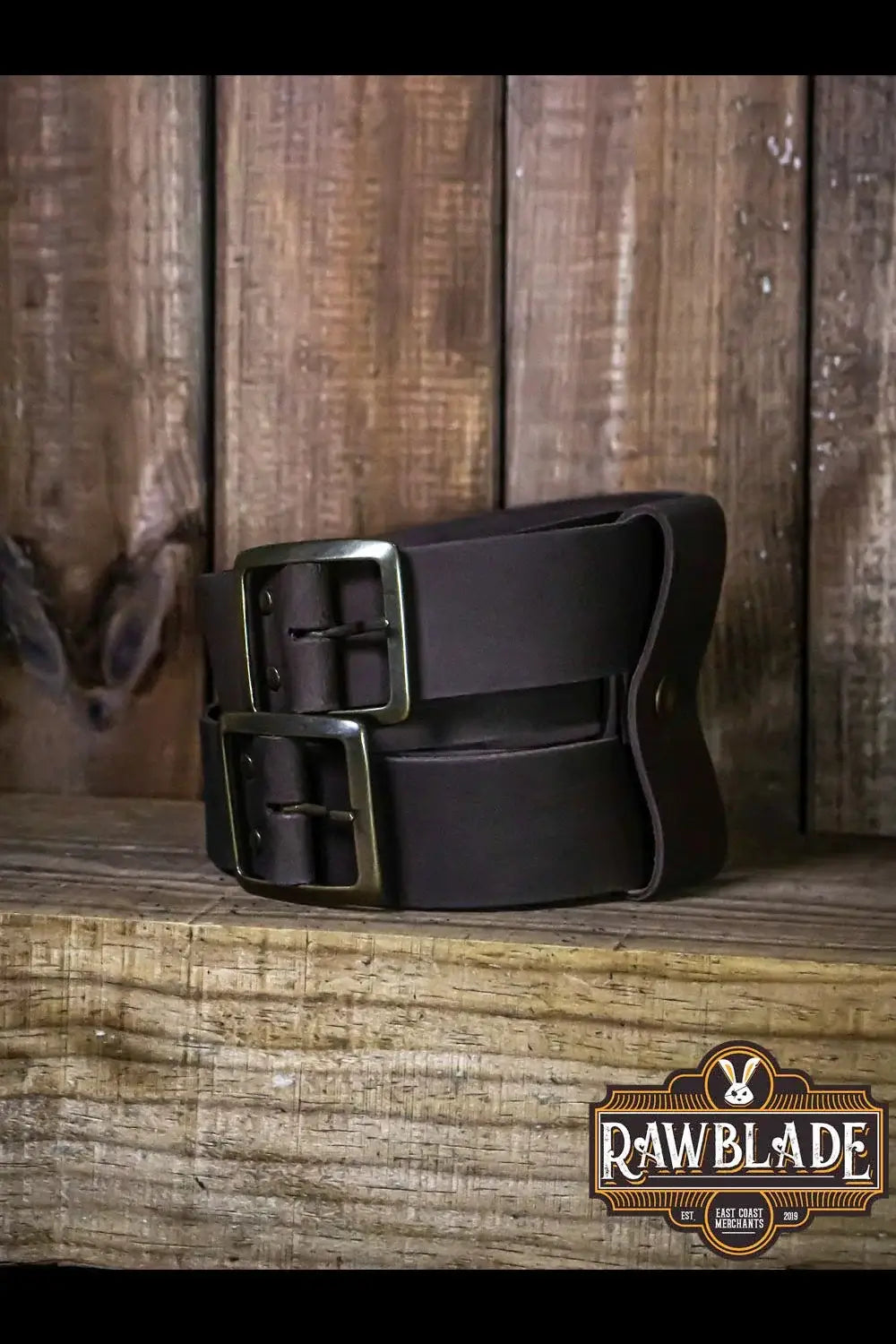 Beligor Double Belt displayed on rustic wooden surface, showcasing high-quality leather construction and double buckle design.