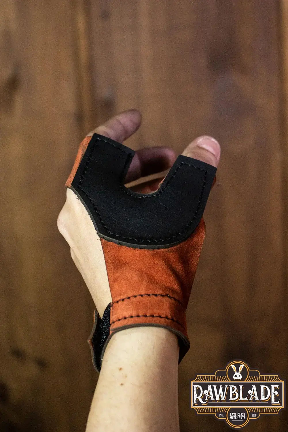 Archery Glove Oren in orange and black, showcasing wrist adjustment and leather details for archery protection.