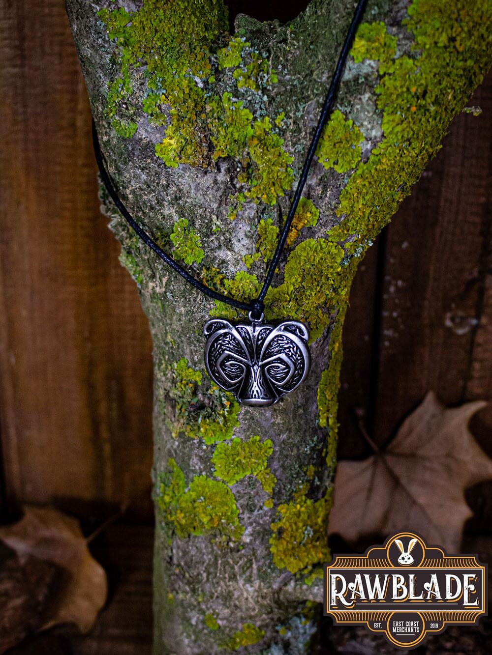 Bear Clan Pendant displayed on a tree trunk, showcasing its detailed bear's head design and natural vibe.