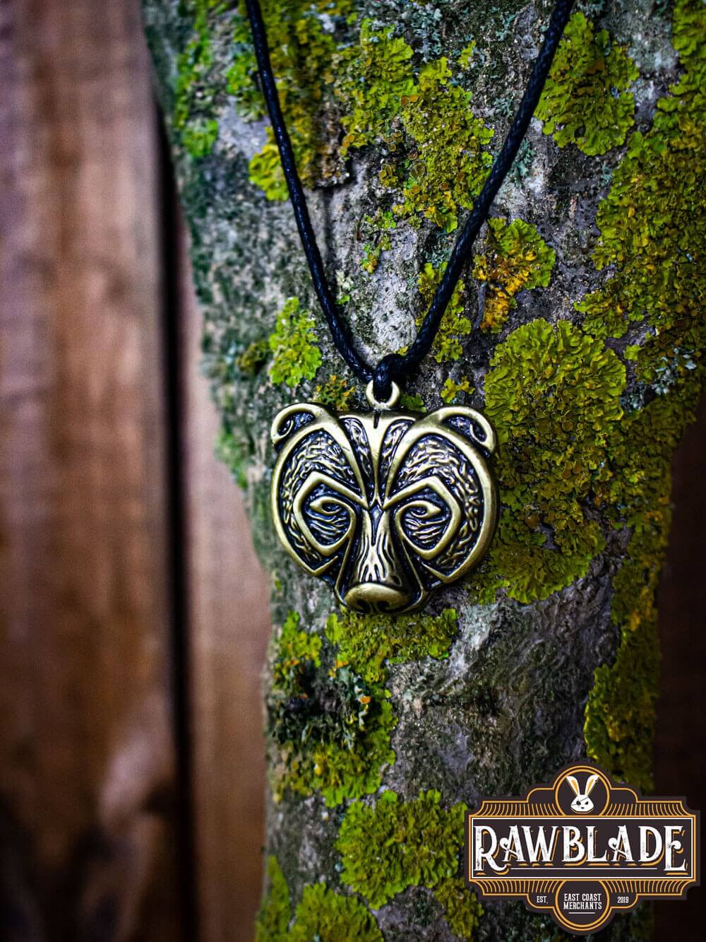 Bear Clan Pendant hanging on a wooden tree with unique bear head design, showcasing strength and nature connection.