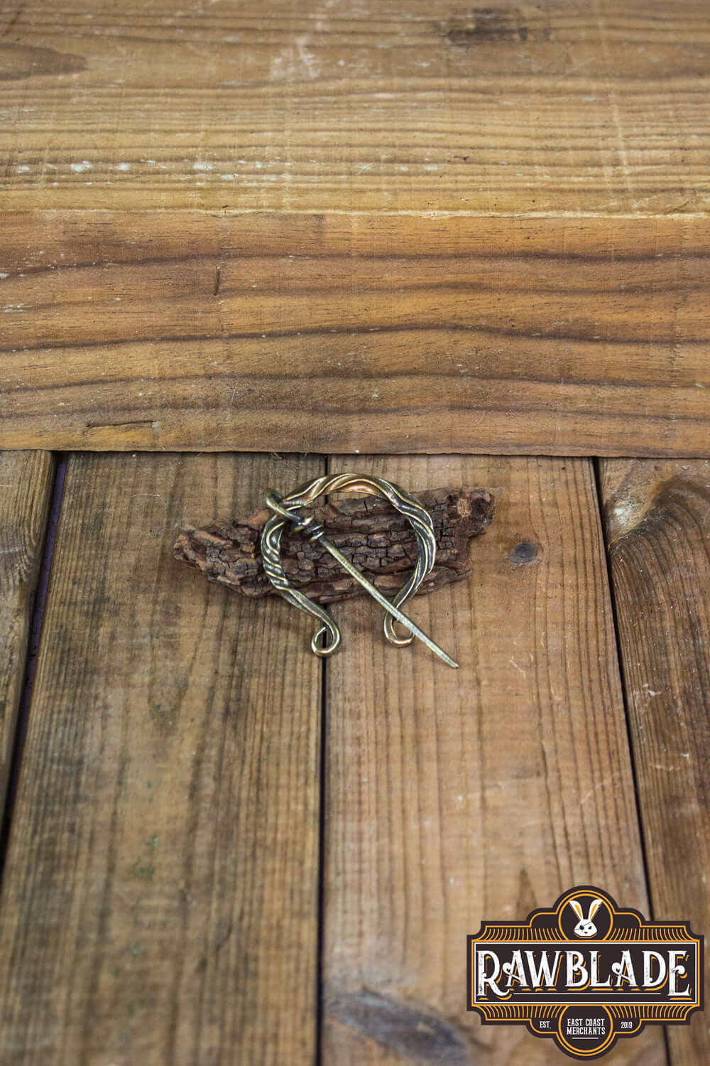 Braided Fibula displayed on wooden surface, perfect for medieval costumes and cosplay.