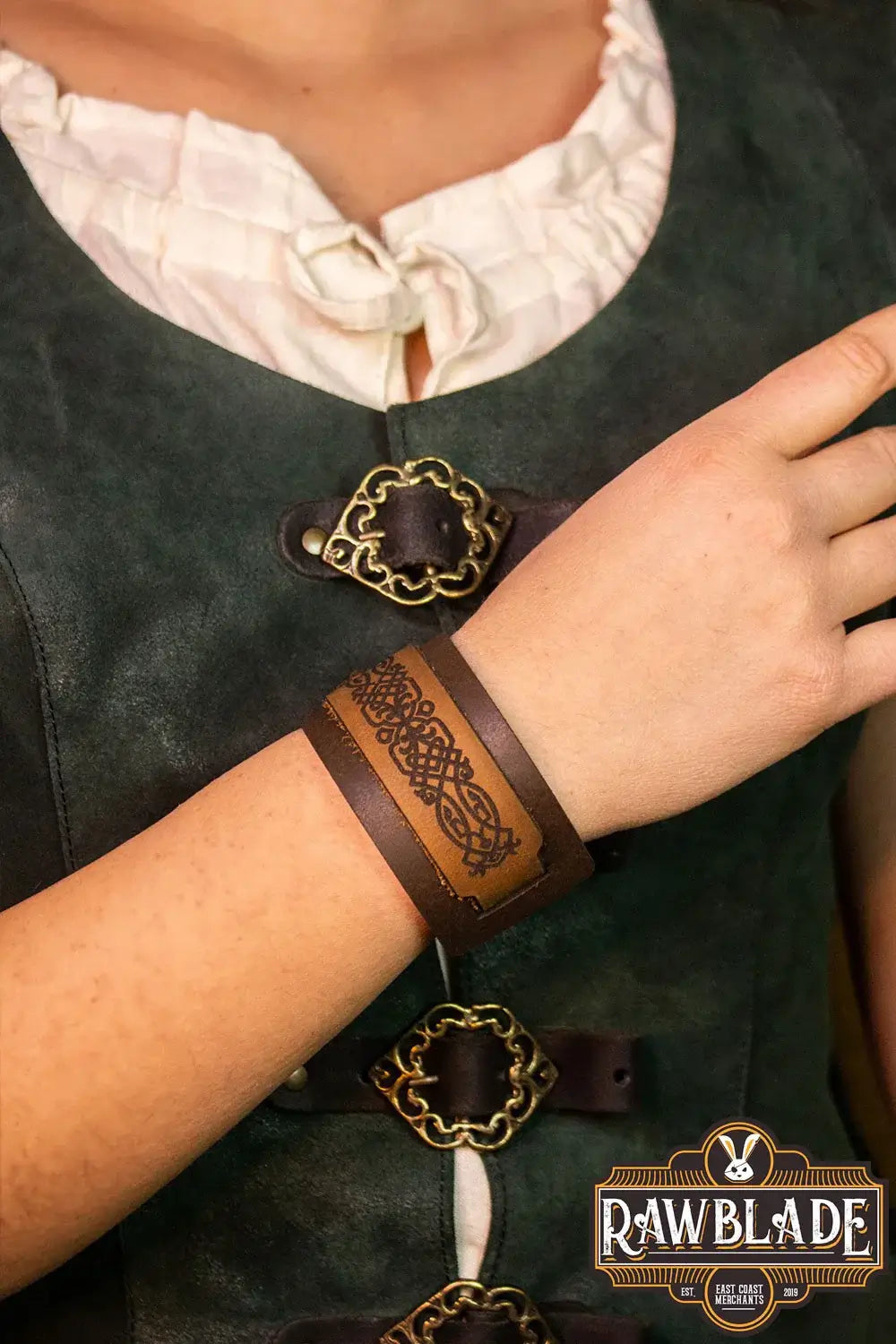 Beleriand Leather Bracelet worn on a person's wrist, featuring engraved black filigrees and a golden buckle.