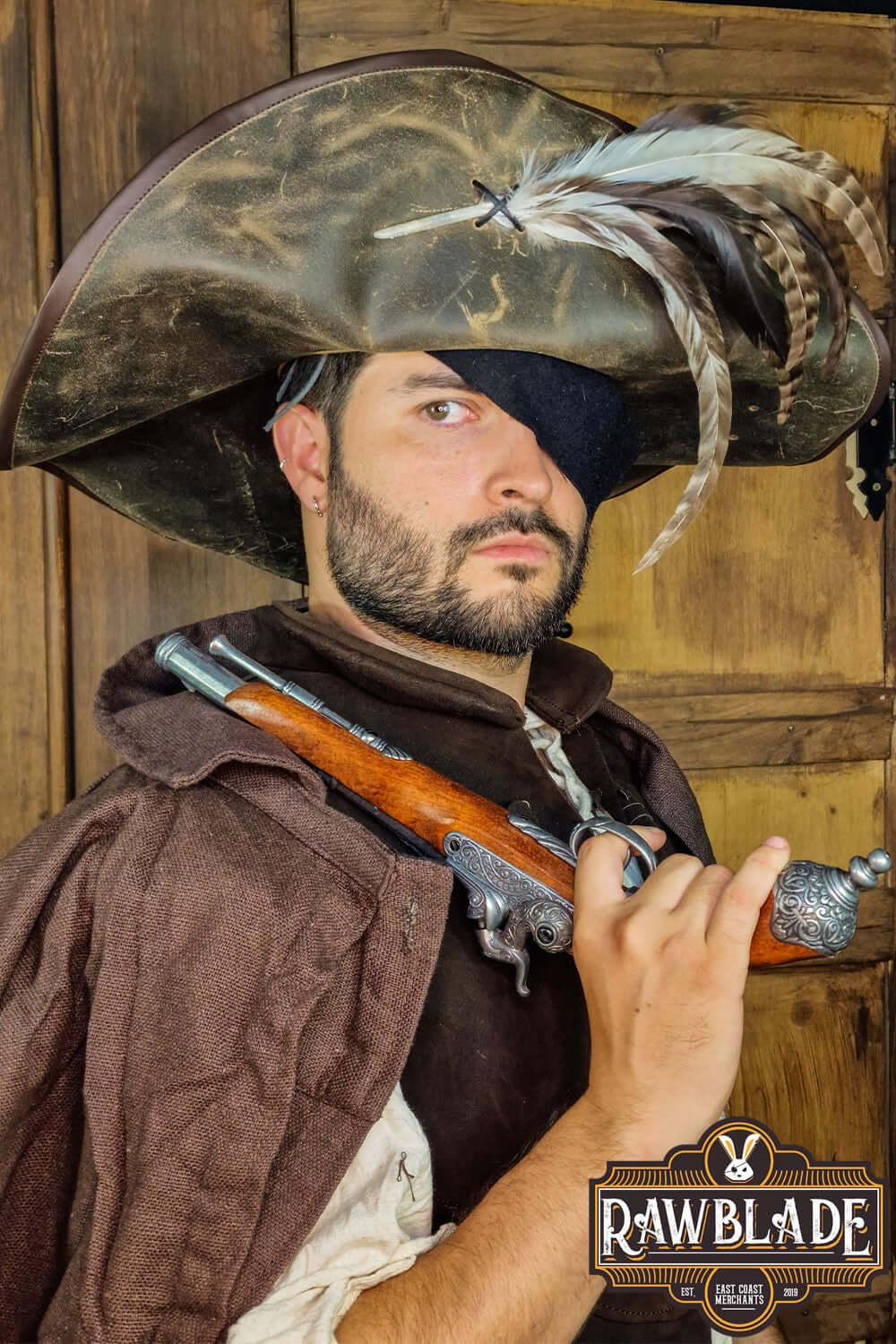 Captain Teague Hat with Feathers worn by a pirate character holding a pistol with a weathered backdrop.