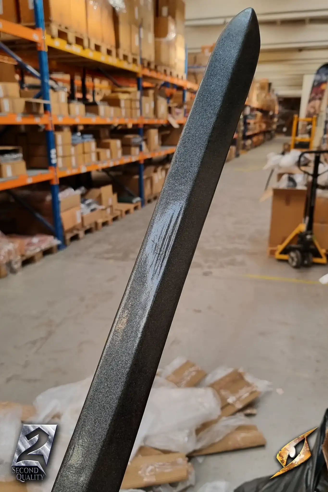2nd Quality – Landsknecht Greatsword showing the blade in a warehouse setting, highlighting its sleek design and finish.