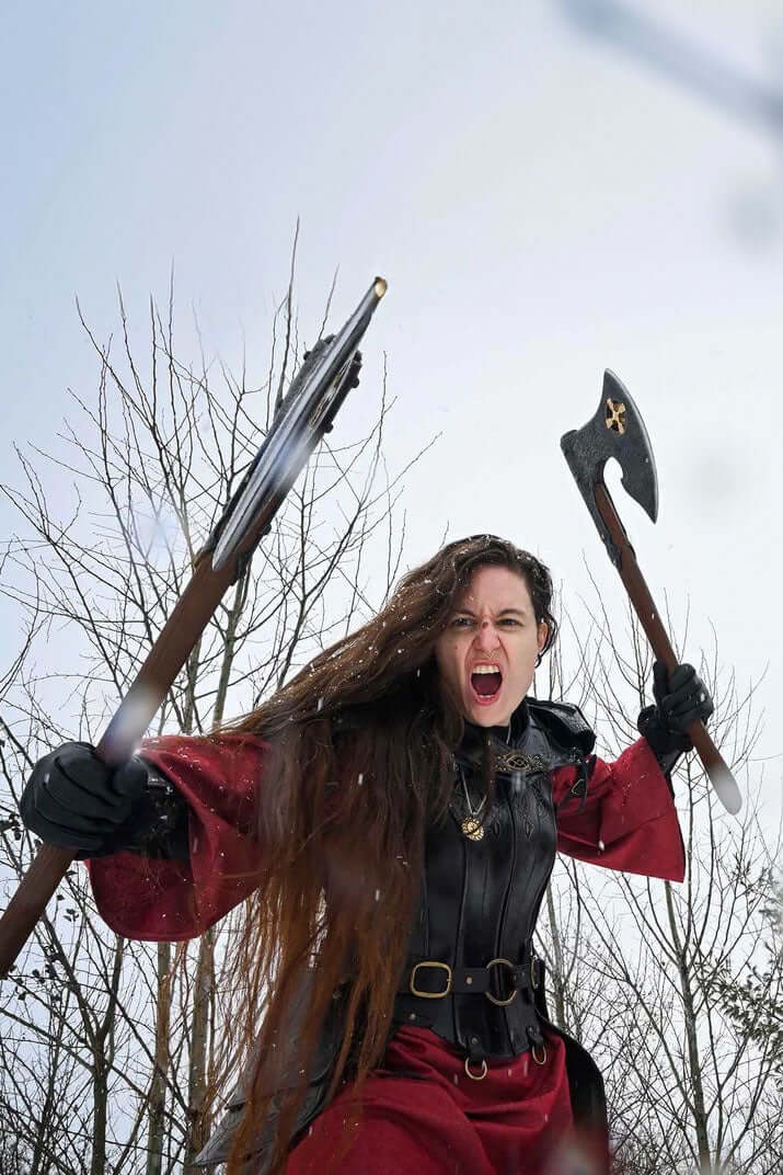 Baruk II axe wielded by a warrior in dramatic pose, showcasing strength and determination in snowy landscape.