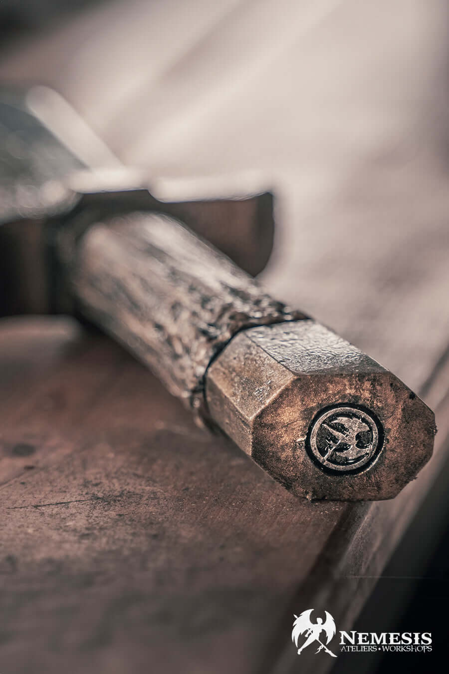 Close-up of a Bowie knife handle, showcasing intricate details and craftsmanship in a rustic setting.
