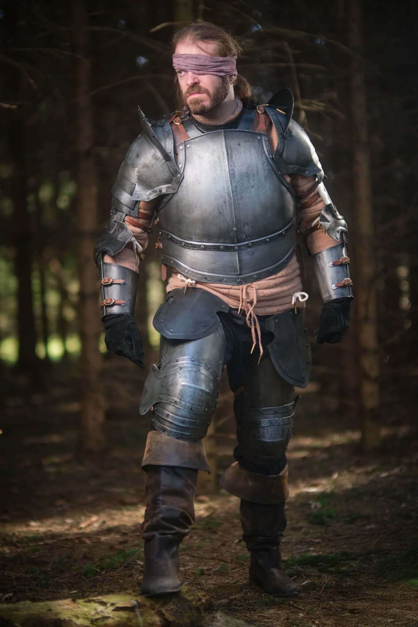 Person in full armor standing in a forest
