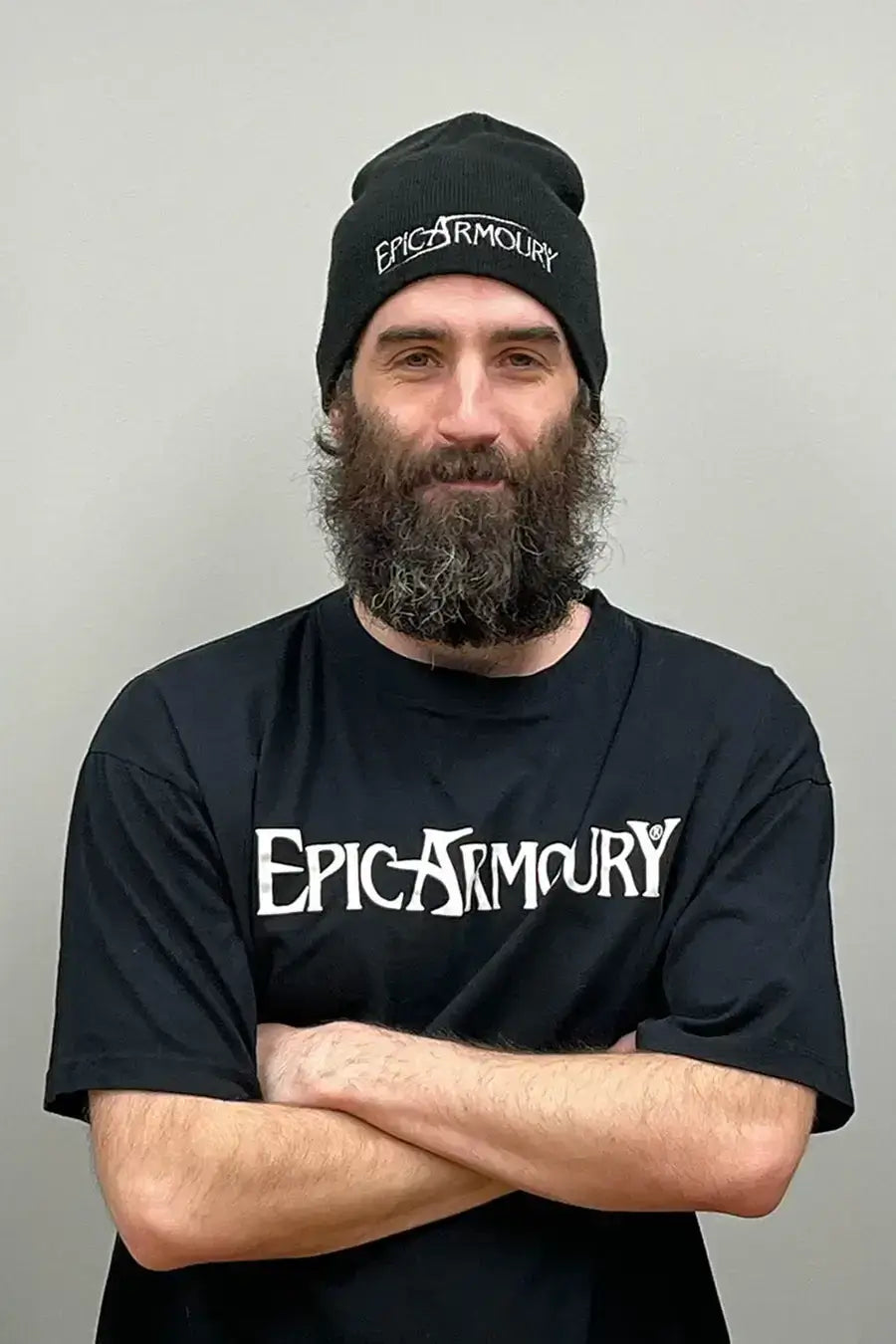 Man with beard wearing an Epic Armoury t-shirt and beanie, showcasing a relaxed, confident pose.