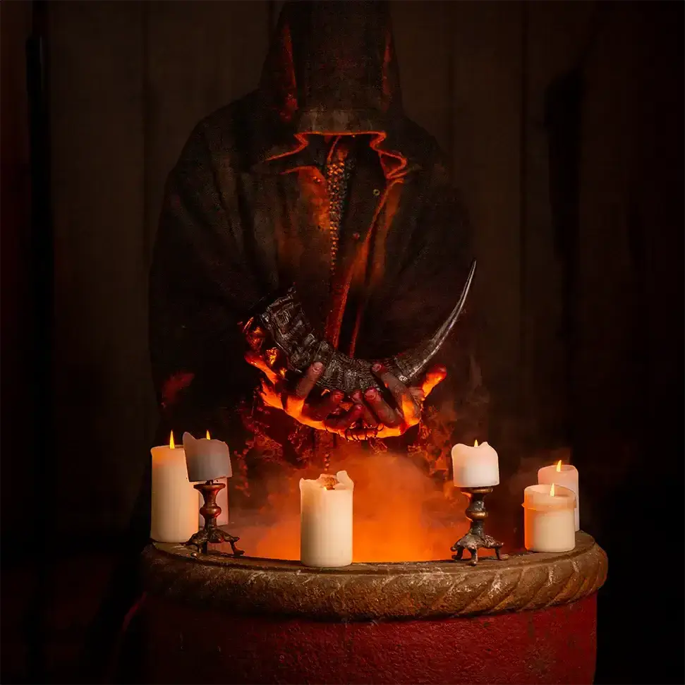 Mysterious figure in dark hood holding a horn in front of lit candles and a cauldron, creating a mystical atmosphere.