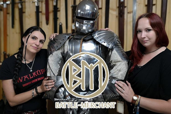 Two women beside a knight in armor, showcasing Battle Merchant's logo, reflecting medieval themes and craftsmanship.