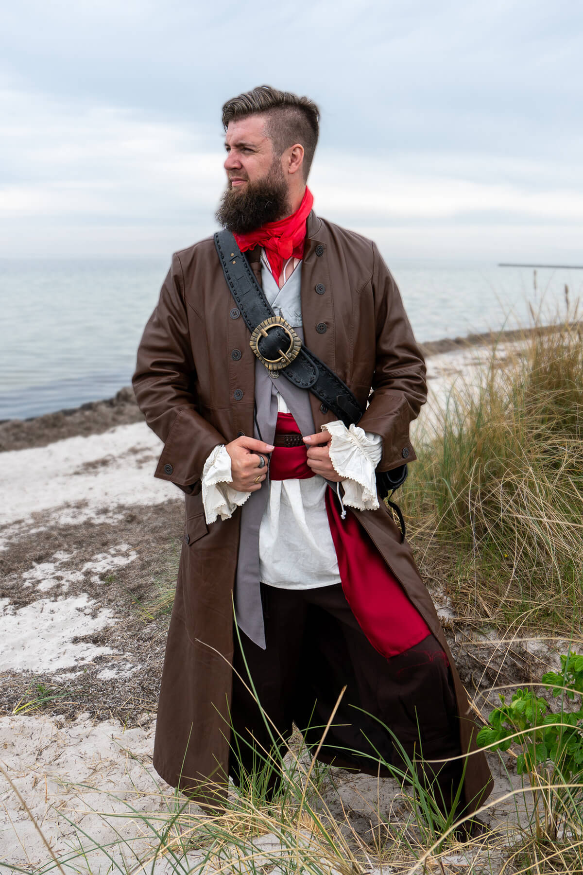 Man in historical pirate costume standing on a beach
