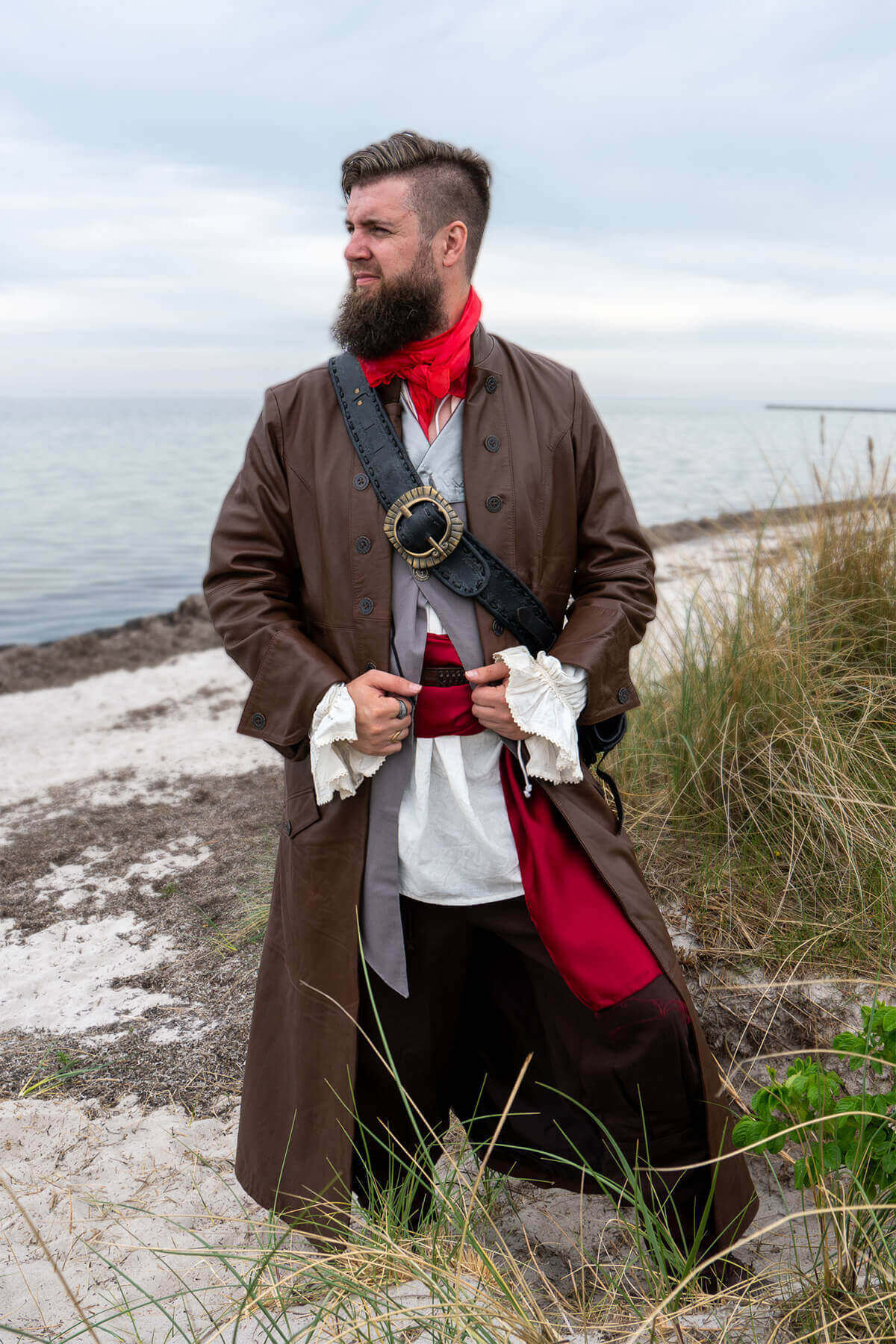 Man in historical pirate costume standing on a beach