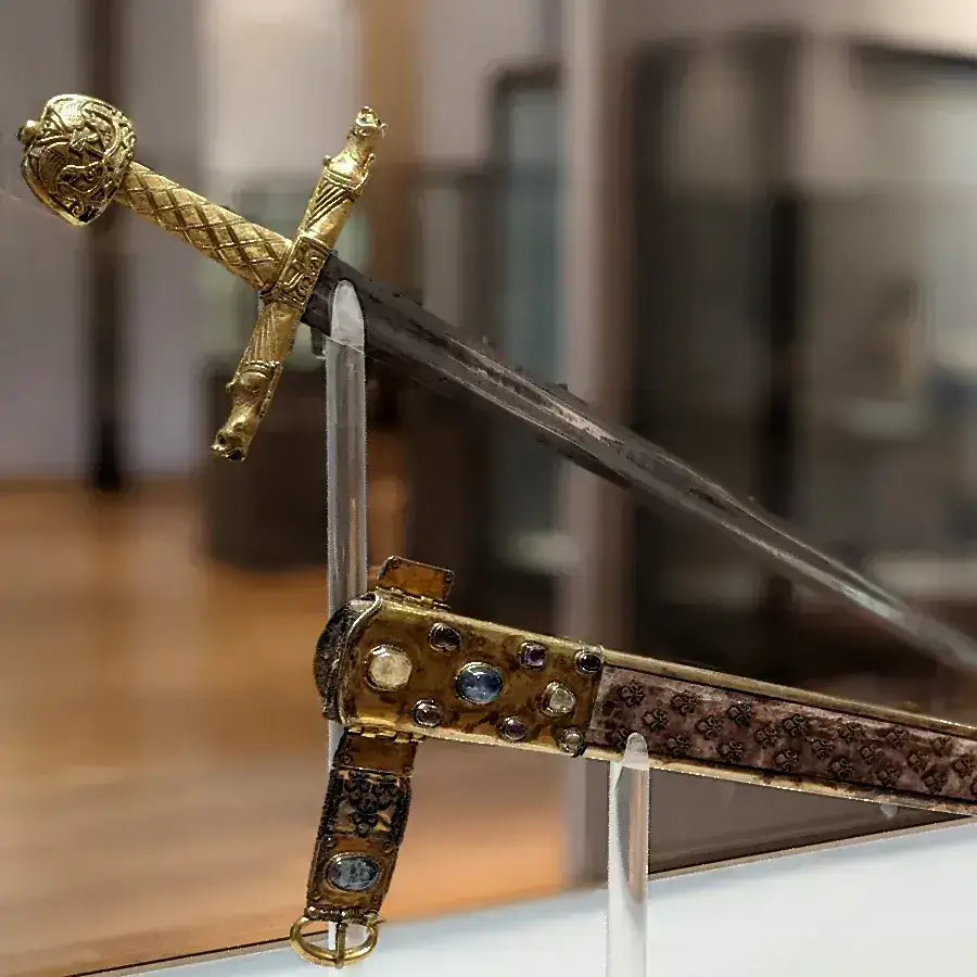 Intricately designed historic sword displayed in a museum, featuring a gold hilt and ornate scabbard.