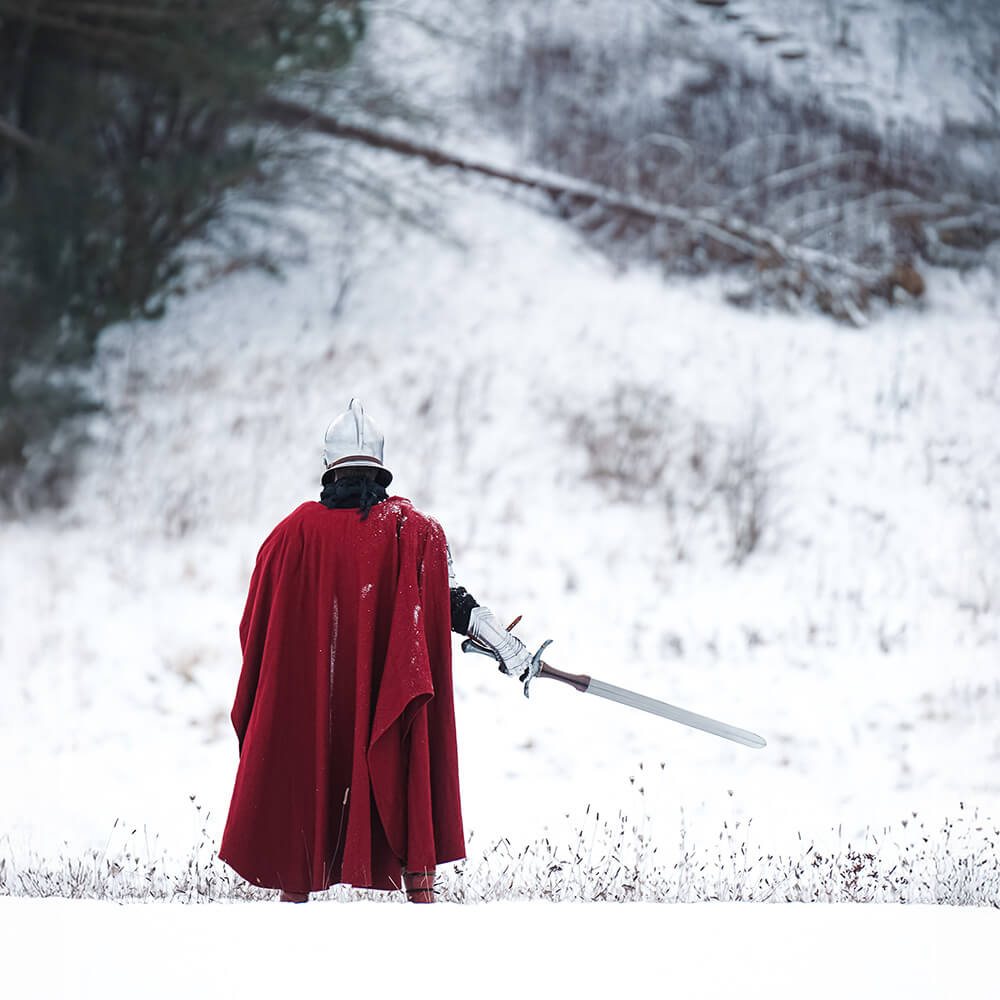A medieval warrior in a red cape holding a sword, ideal for 50 significant historical Medieval events to inspire LARP narratives.