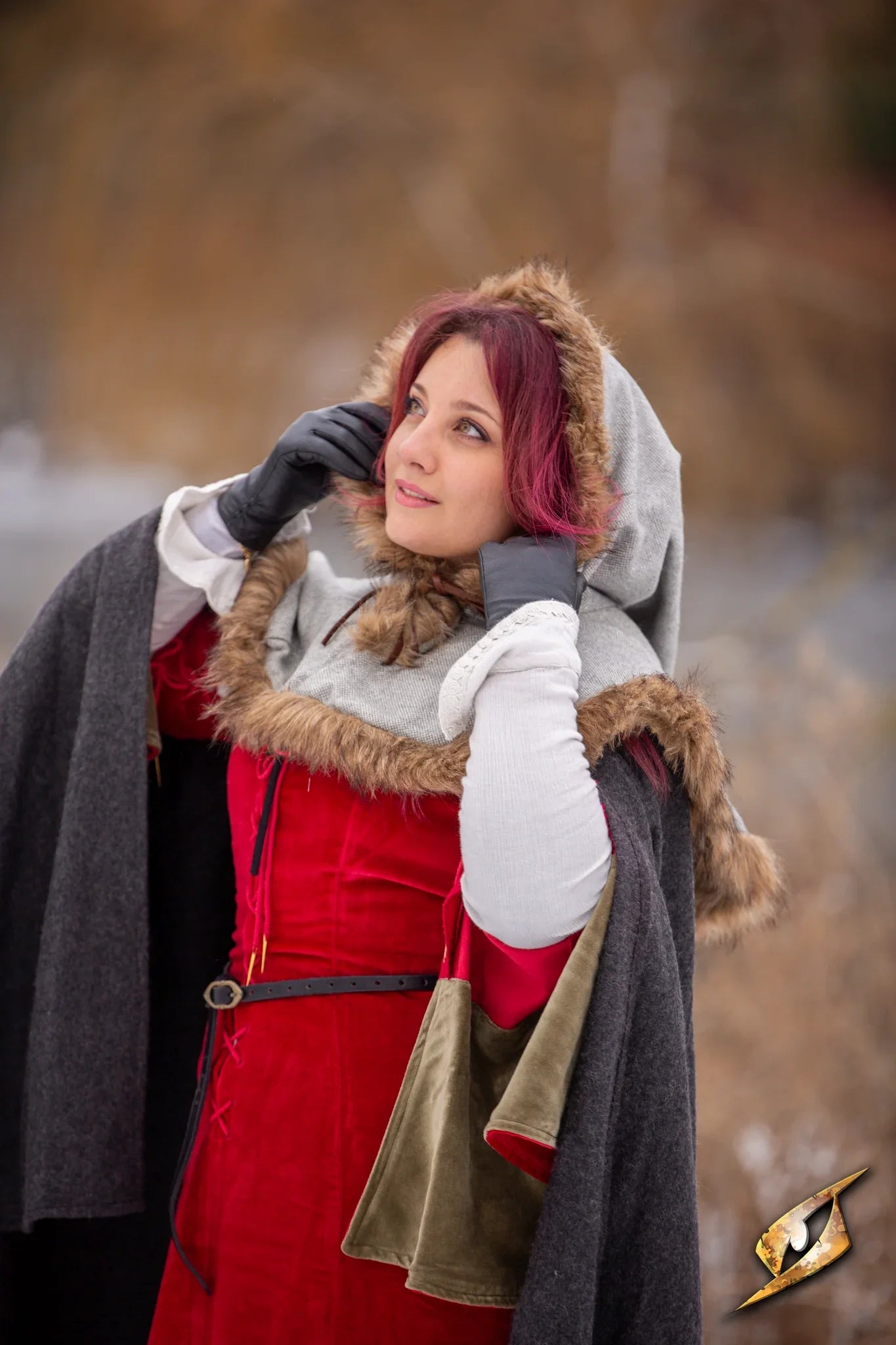 Woman in medieval style clothing, with a blurry forest background behind