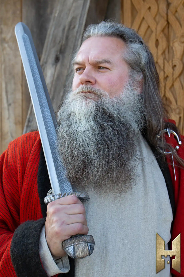 EirikR Sword - 83 cm held by a bearded man in historical attire, showcasing the sword's Viking design and craftsmanship.