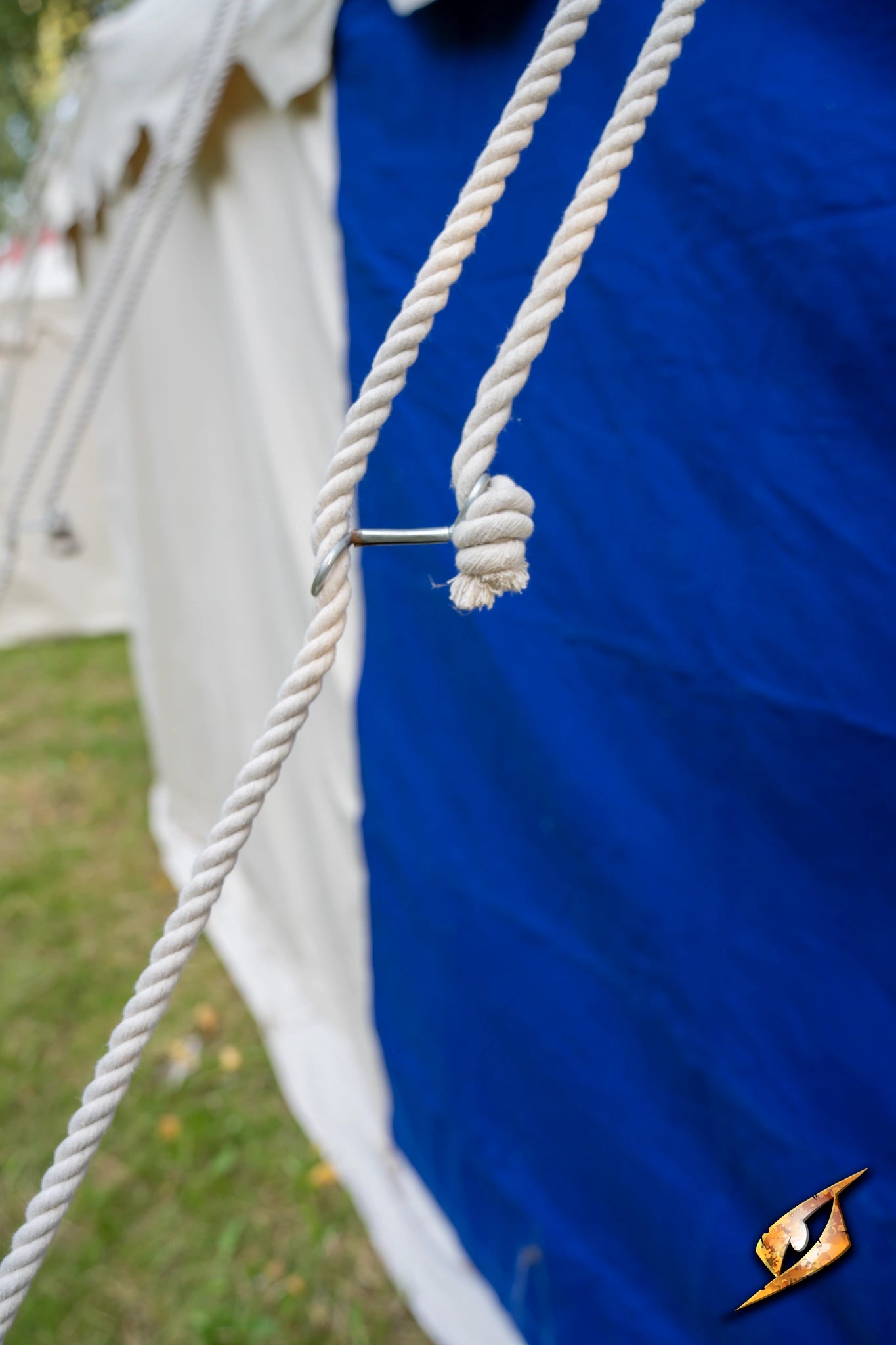 Close-up of a rope knot securing the Marquee Tent - 4x6m against a blue backdrop.