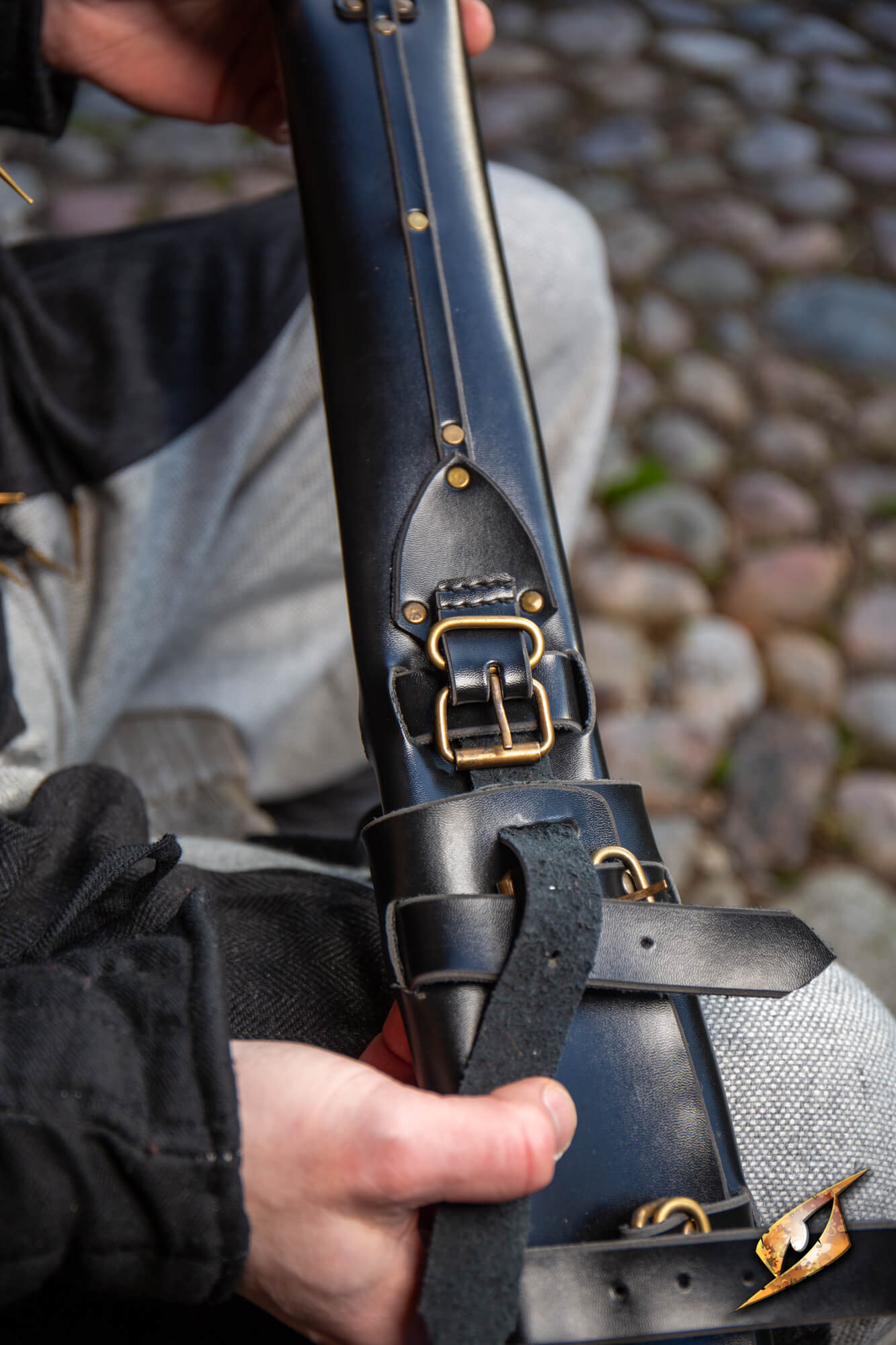 Adjustable Scabbard - Faux Leather held by a person, showcasing its adjustable straps and sleek design.