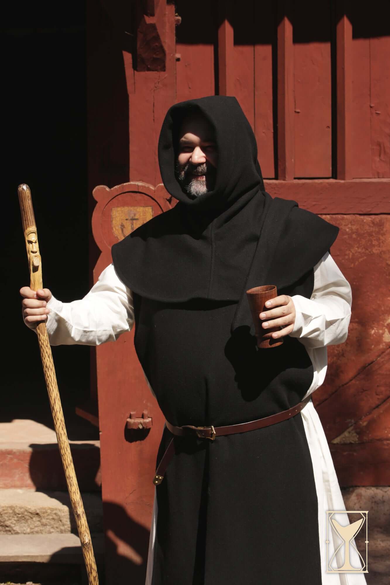 Simple Liripipe Hood - Brushed Wool worn by a man holding a staff and a cup, set against a rustic red background.
