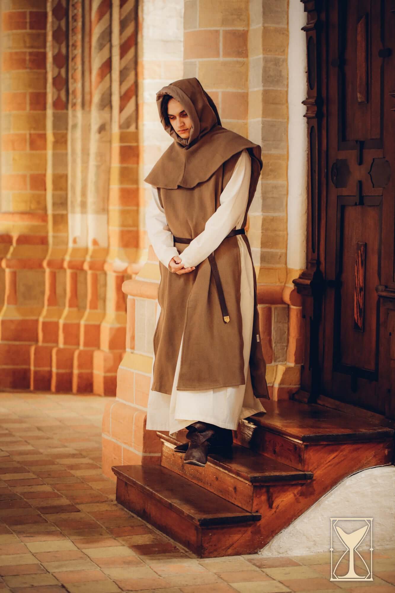 Simple Liripipe Hood - Brushed Wool worn by a person on steps in a medieval setting.